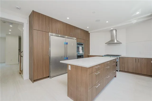 a kitchen with kitchen island a sink stove and refrigerator