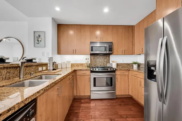 a kitchen with granite countertop a sink a counter space and cabinets