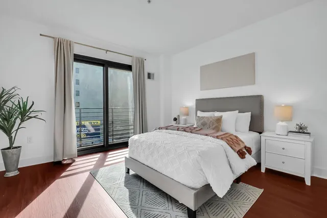 a bedroom with a bed and wooden floor