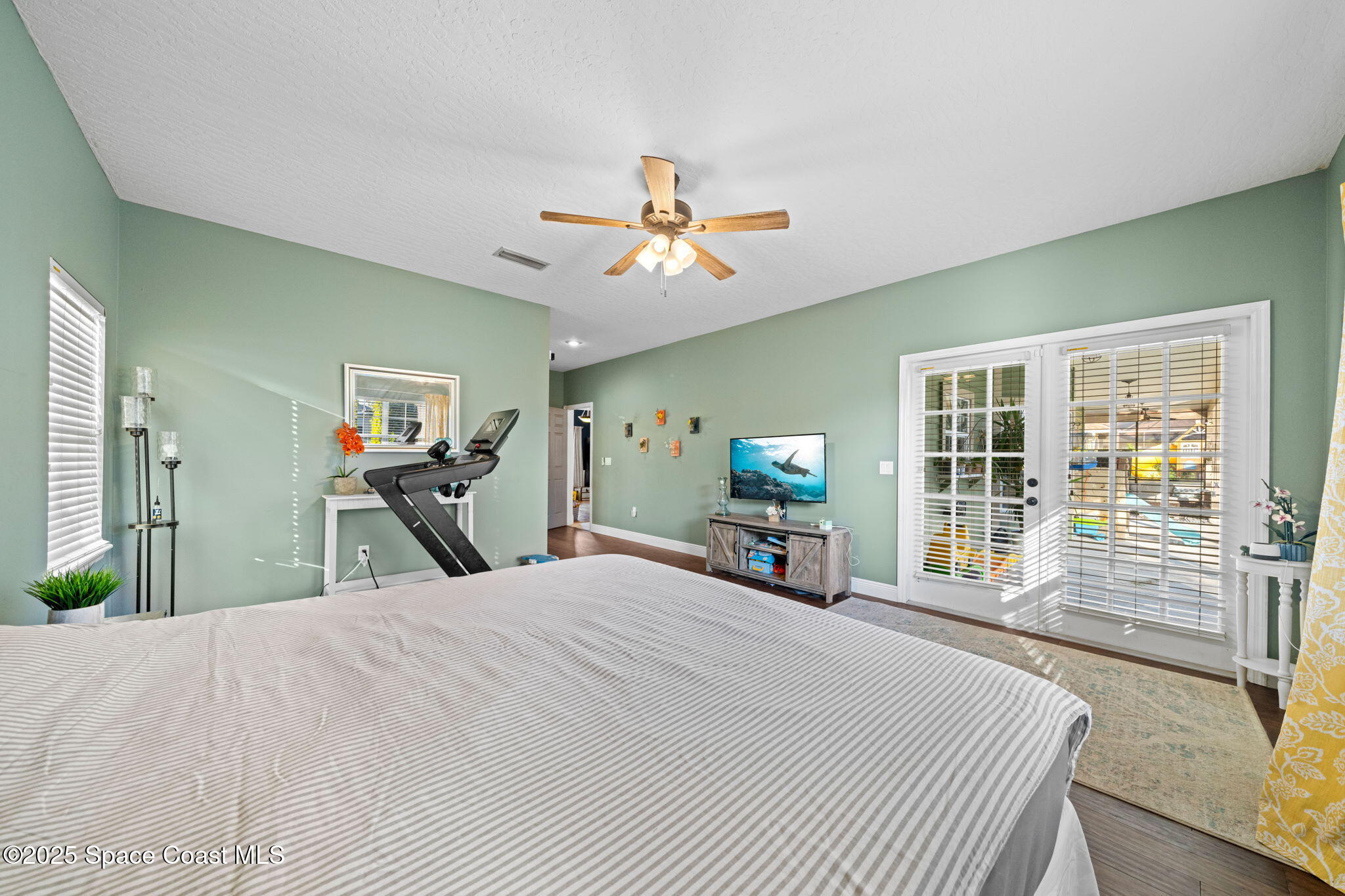 3705 Eagle Way Melbourne, FL 32934 - Photo 29 of 47 a room with a bed a large window and flat screen tv