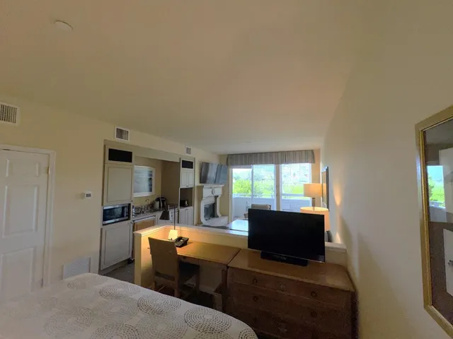 a living room with furniture a flat screen tv and large window