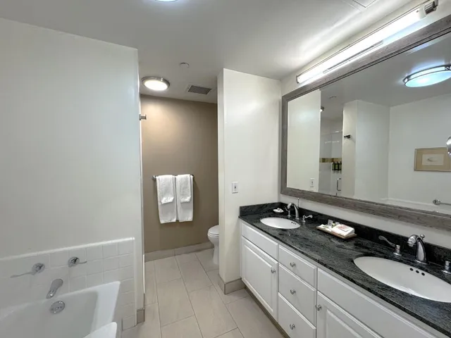 a spacious bathroom with a granite countertop sink and a mirror