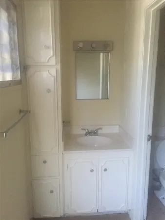 a bathroom with a granite countertop sink and mirror