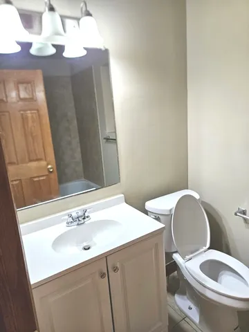 a bathroom with a toilet sink and mirror