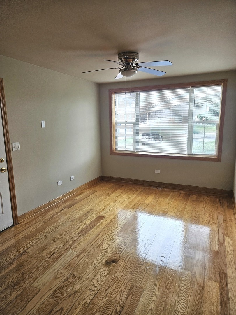 5316 South Kenneth Avenue, Unit 101 Chicago, IL 60632 - Photo 9 of 15 an empty room with wooden floor and windows