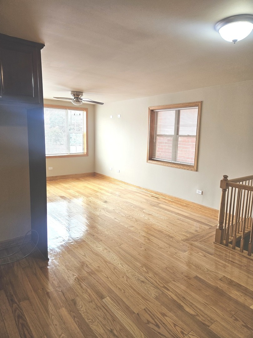 5316 South Kenneth Avenue, Unit 101 Chicago, IL 60632 - Photo 10 of 15 an empty room with wooden floor and windows