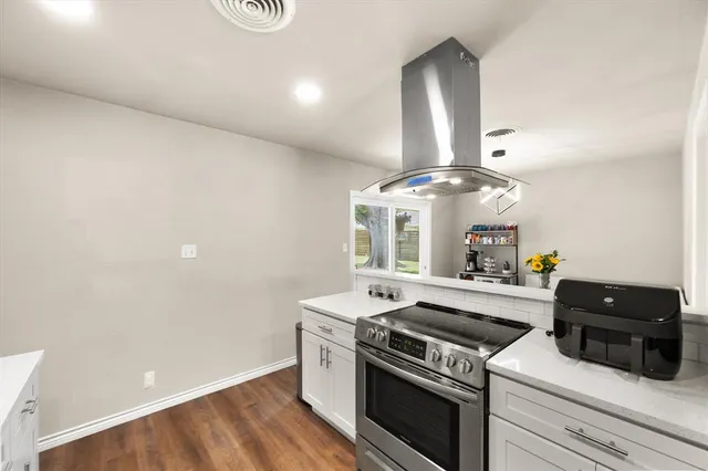a kitchen with a stove and a chandelier