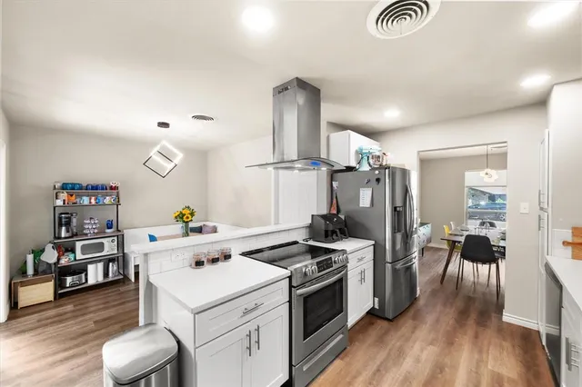 a kitchen that has a lot of cabinets a sink and appliances