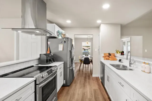 a kitchen with a stove and a wooden floor