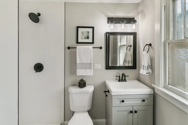 a bathroom with a toilet sink and mirror
