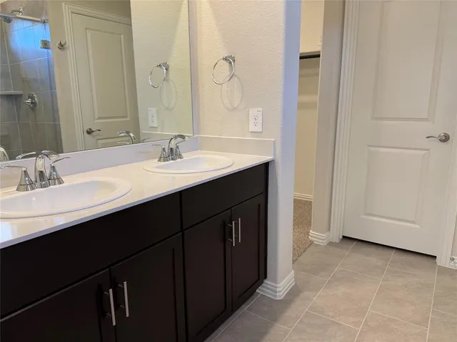 a bathroom with a double vanity sink and a mirror