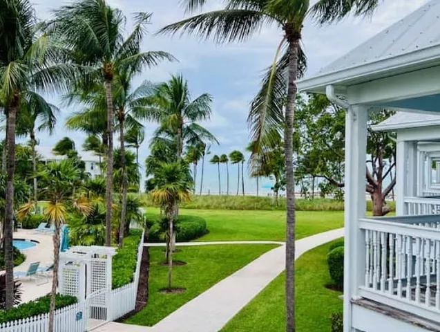 a view of a house with a yard and potted plants