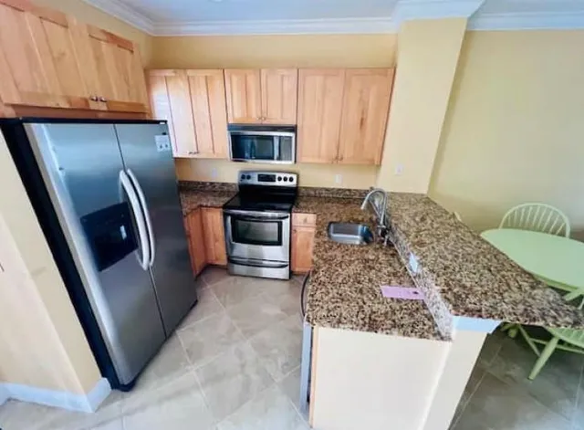 a kitchen with stainless steel appliances granite countertop a refrigerator a stove top oven a sink and dishwasher