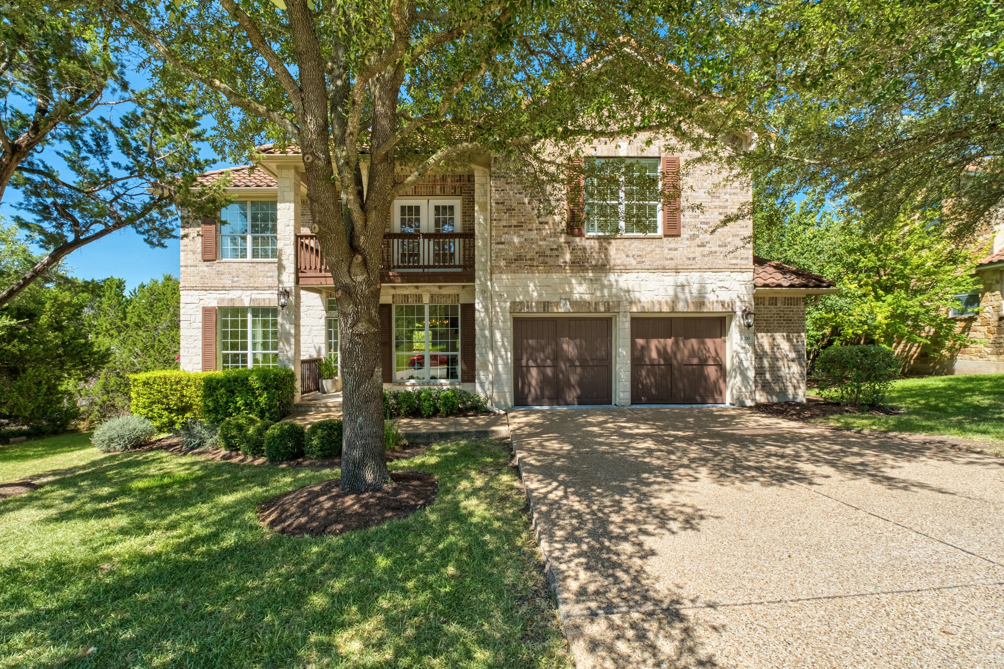 16200 Spillman Ranch Loop Austin, TX 78738 - Photo 3 of 36 A charming brick and stone facade welcomes with a double garage and mature landscaping.