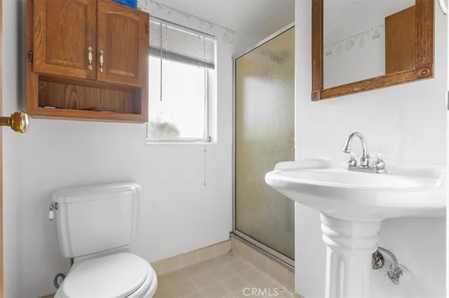a bathroom with a toilet a sink and mirror
