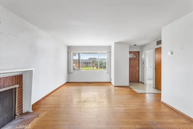 a view of an empty room with glass door and wooden floor