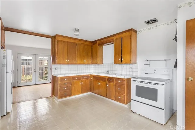 a kitchen with granite countertop a stove a sink and a refrigerator
