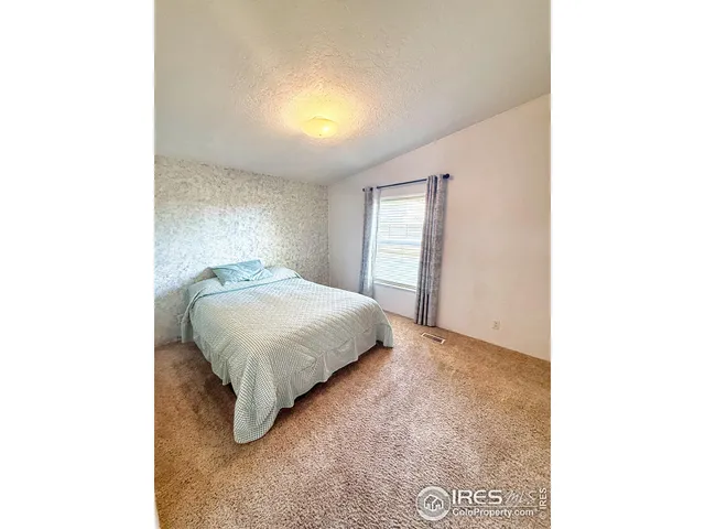 a bedroom with a bed and a night stand