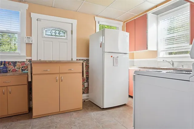 a kitchen with appliances a refrigerator a sink and cabinets