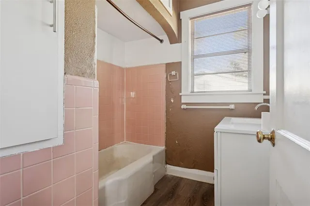 a bathroom with a tub a sink and a vanity