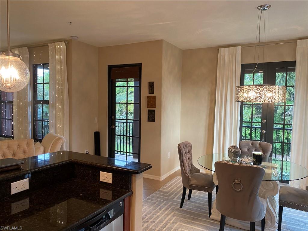 8997 Cambria Circle, Unit 2002 Naples, FL 34113 - Photo 19 of 35 a view of a dining room with furniture and chandelier