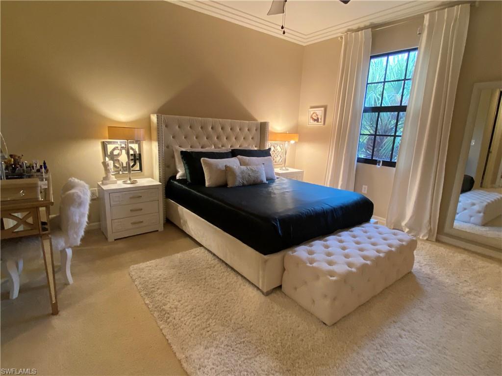 8997 Cambria Circle, Unit 2002 Naples, FL 34113 - Photo 25 of 35 a bedroom with a bed and a window