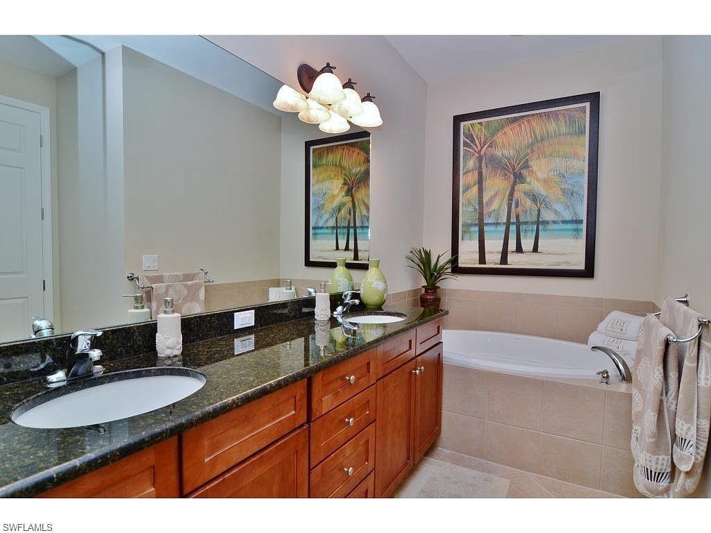 8997 Cambria Circle, Unit 2002 Naples, FL 34113 - Photo 28 of 35 a bathroom with a granite countertop sink and a mirror