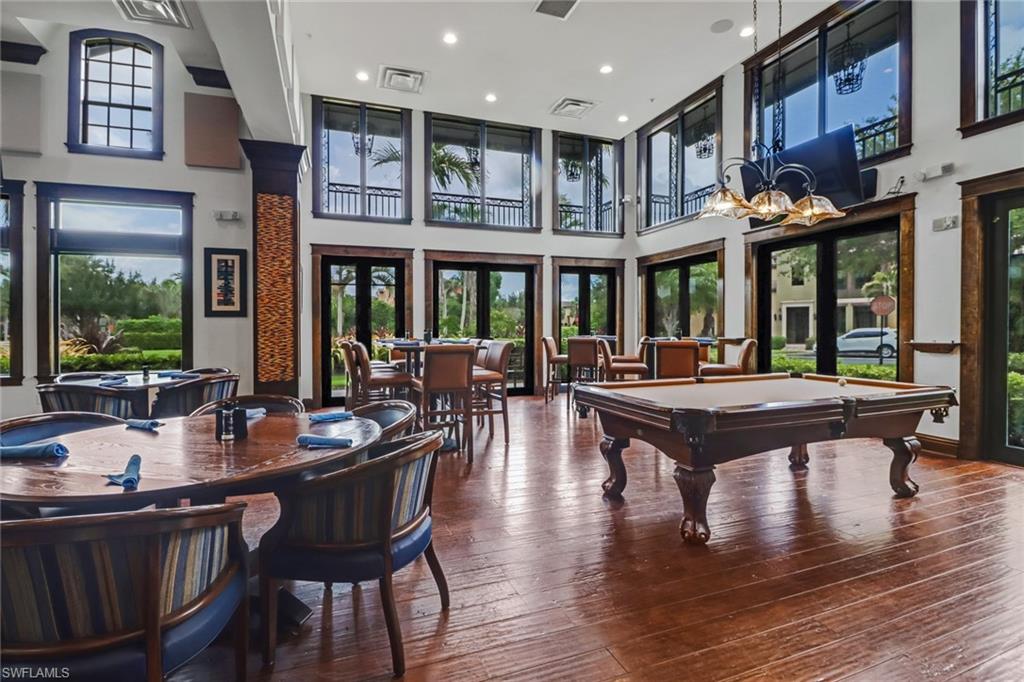 8997 Cambria Circle, Unit 2002 Naples, FL 34113 - Photo 5 of 35 a dining hall with stainless steel appliances granite countertop a stove a kitchen island a dining table and chairs