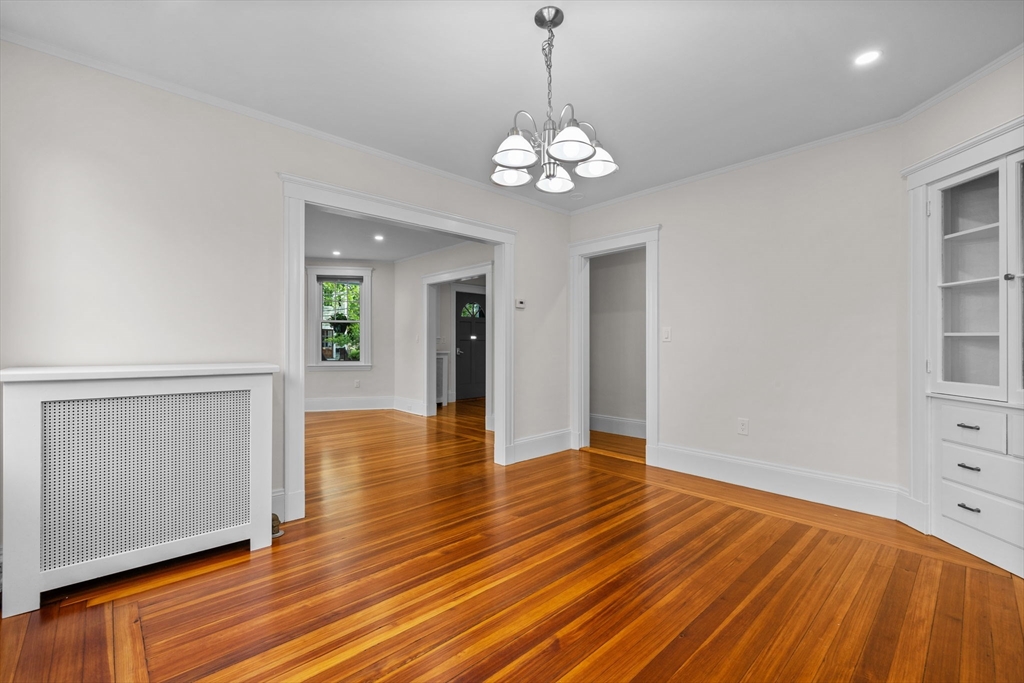 37 Fountain Road, Unit 1 Arlington, MA 02476 - Photo 8 of 19 a view of an empty room with wooden floor and a kitchen