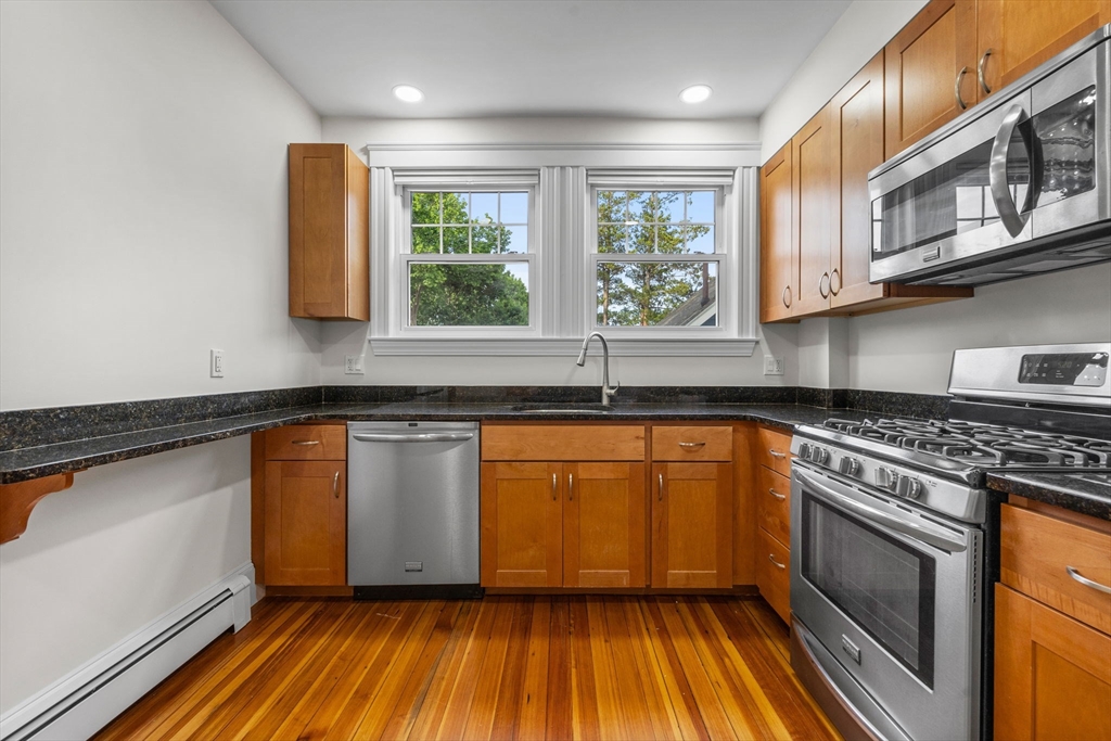 37 Fountain Road, Unit 1 Arlington, MA 02476 - Photo 10 of 19 a kitchen with stainless steel appliances granite countertop wooden cabinets and a stove top oven