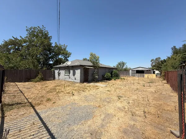 a view of wooden house with a yard