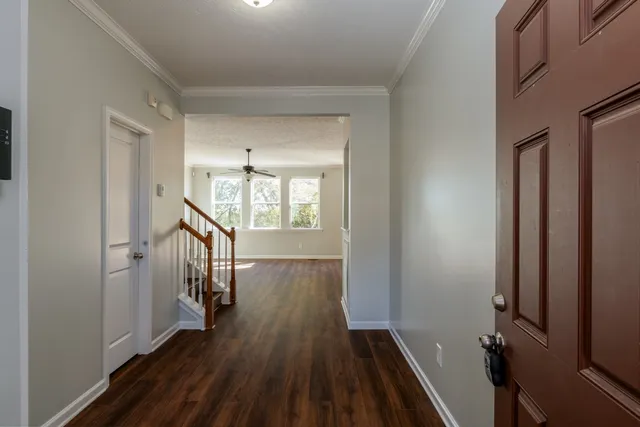 a view of a hallway with wooden floor and stairs