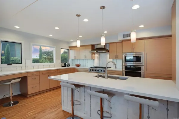 a kitchen with a sink a counter top stainless steel appliances and cabinets