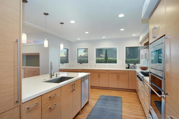 a large kitchen with stainless steel appliances granite countertop a lot of counter space and a sink