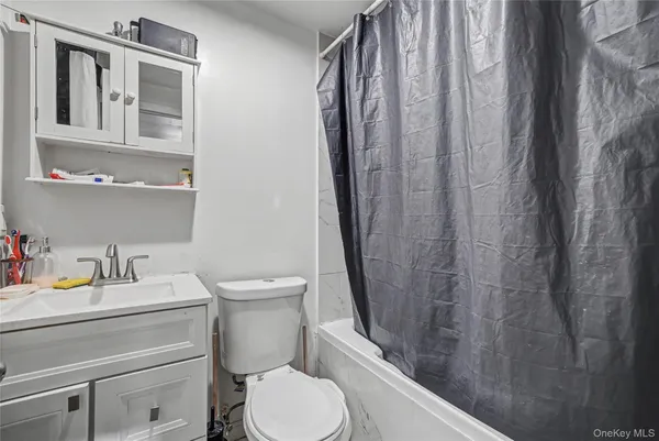 a bathroom with a sink a toilet and shower curtain