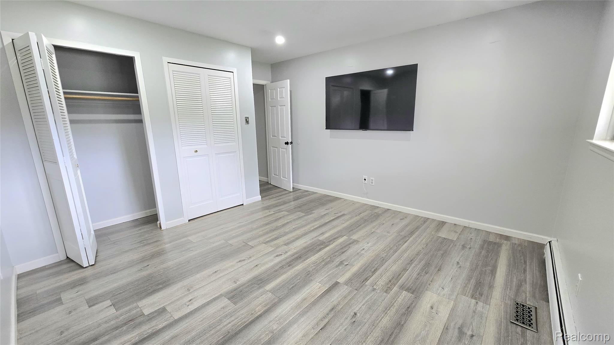 34294 Greentrees Road Sterling Heights, MI 48312 - Photo 10 of 20 Light gray walls, wood-finish flooring, white louvered bifold closet doors, and recessed lighting