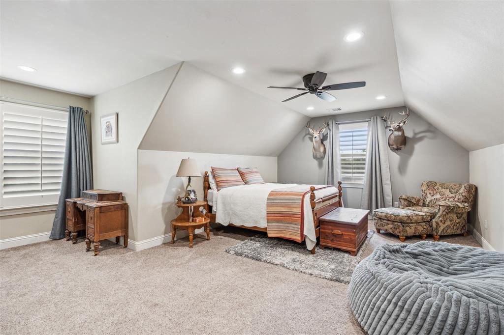 4180 North Smith Road Fate, TX 75087 - Photo 23 of 27 a spacious bedroom with a bed and a ceiling fan