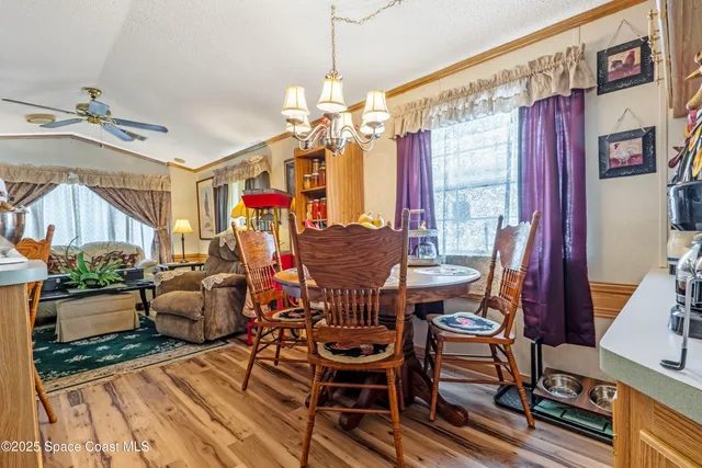 a view of a dining room with furniture a chandelier and wooden floor