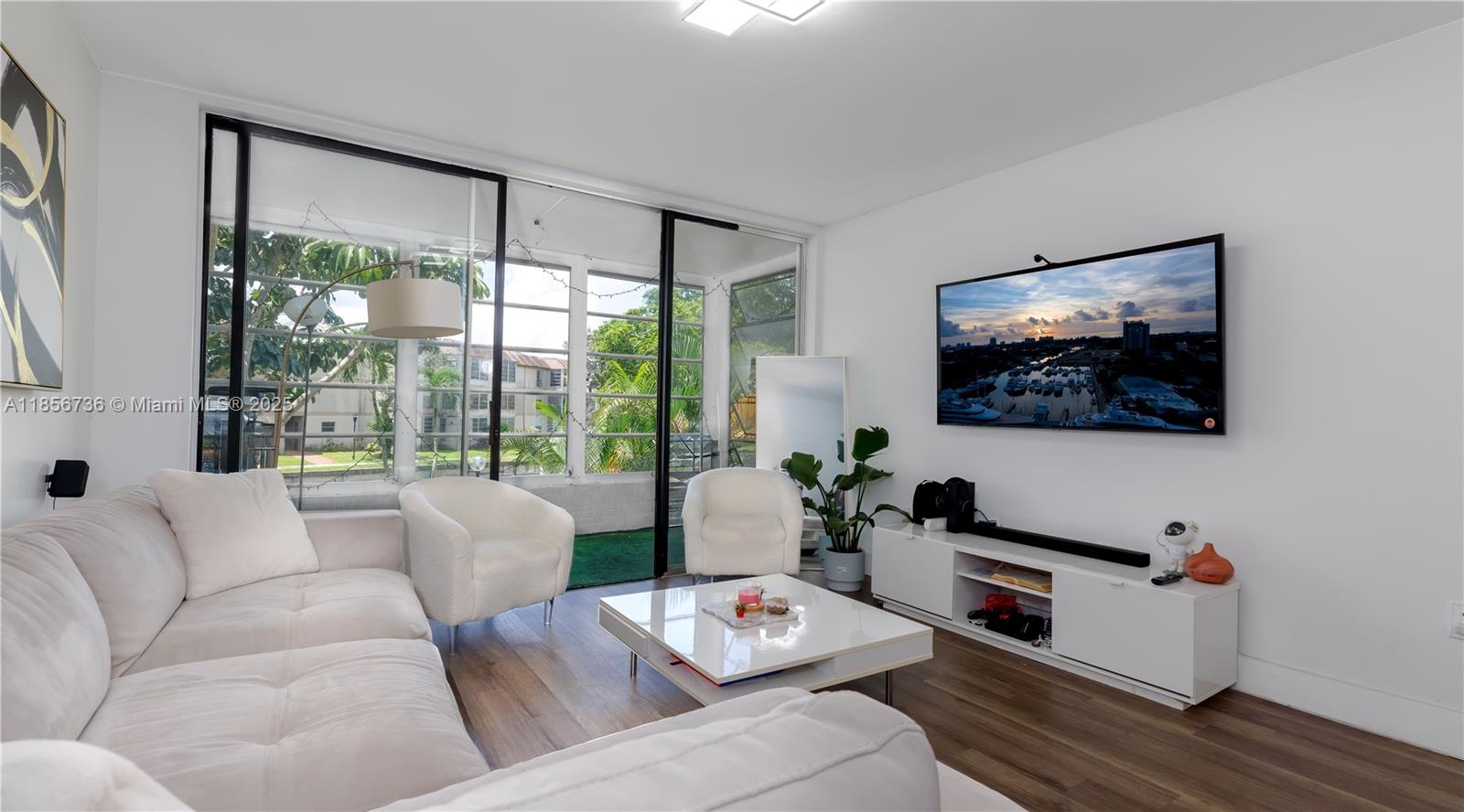 8321 Sands Point Boulevard, Unit D205 Tamarac, FL 33321 - Photo 2 of 18 a living room with furniture and a flat screen tv