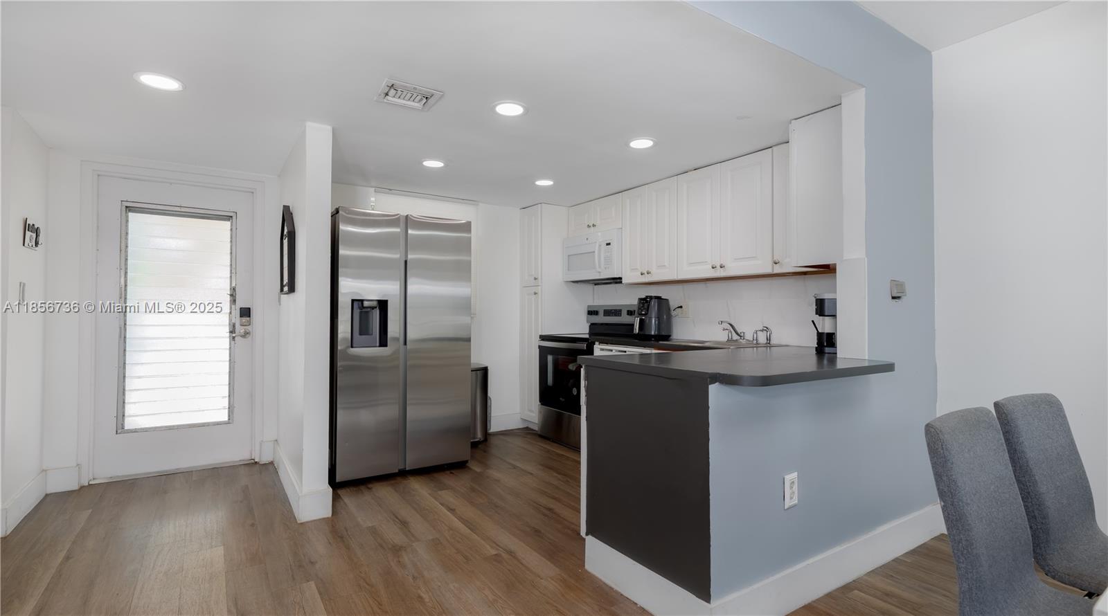 8321 Sands Point Boulevard, Unit D205 Tamarac, FL 33321 - Photo 4 of 18 a kitchen with stainless steel appliances granite countertop a refrigerator sink and cabinets