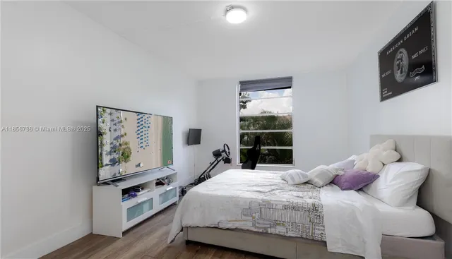 a bedroom with a bed and a flat screen tv