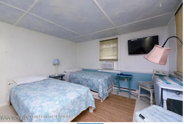 a bedroom with two beds and a flat screen tv