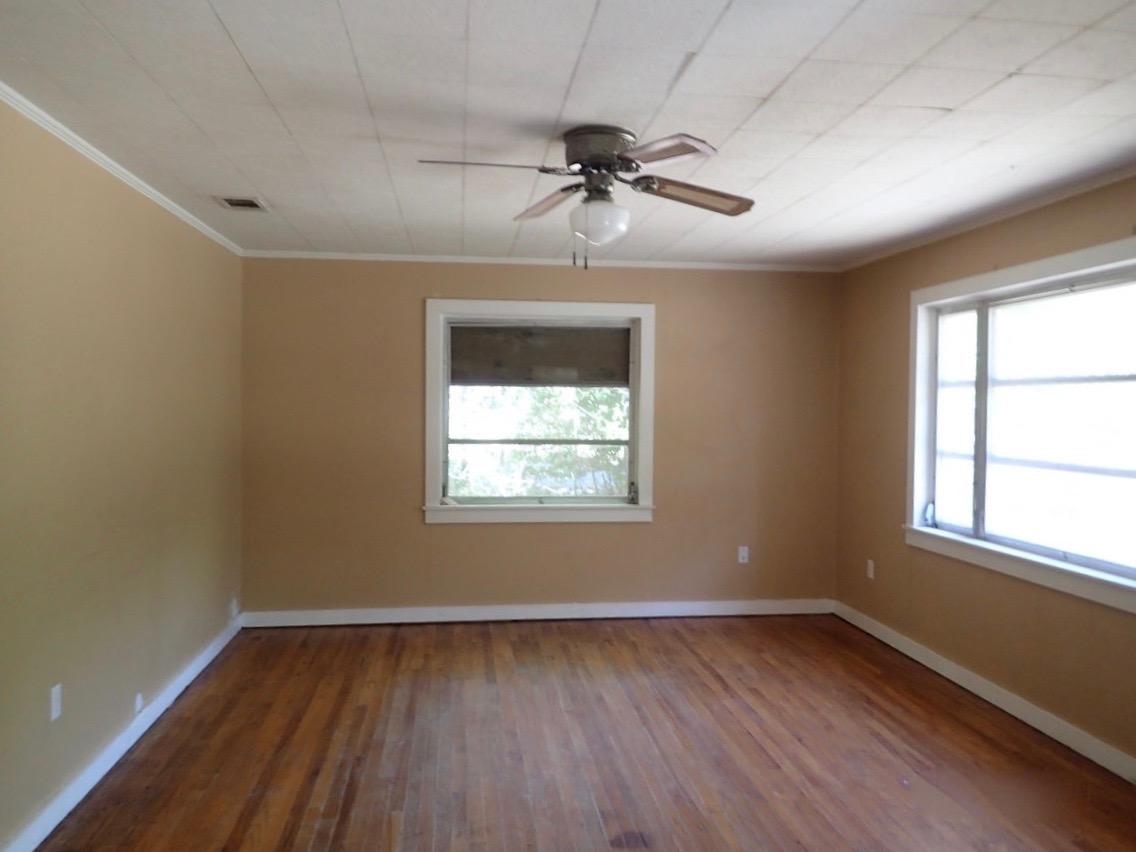 1088 Mapoles Street Crestview, FL 32536 - Photo 2 of 6 wooden floor in an empty room with a window