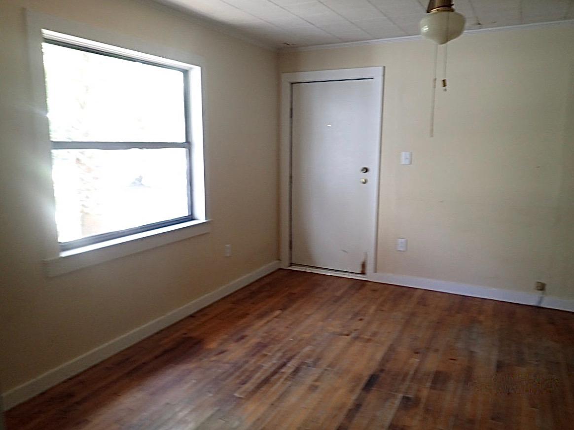 1088 Mapoles Street Crestview, FL 32536 - Photo 4 of 6 an empty room with wooden floor and windows