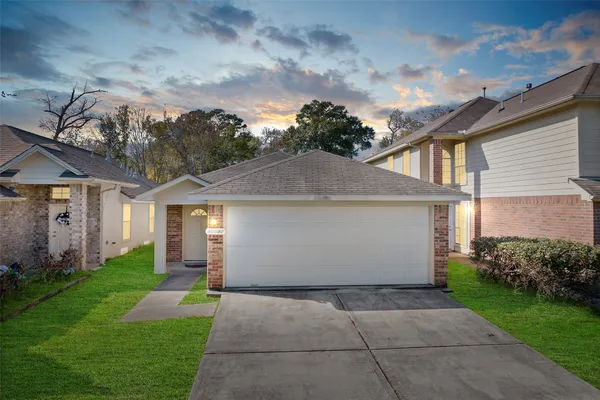 a view of a white house next to a yard with potted plants