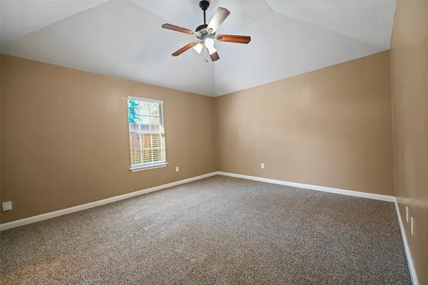 an empty room with windows and fan