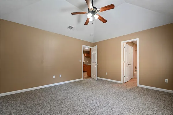an empty room with closet and a ceiling fan