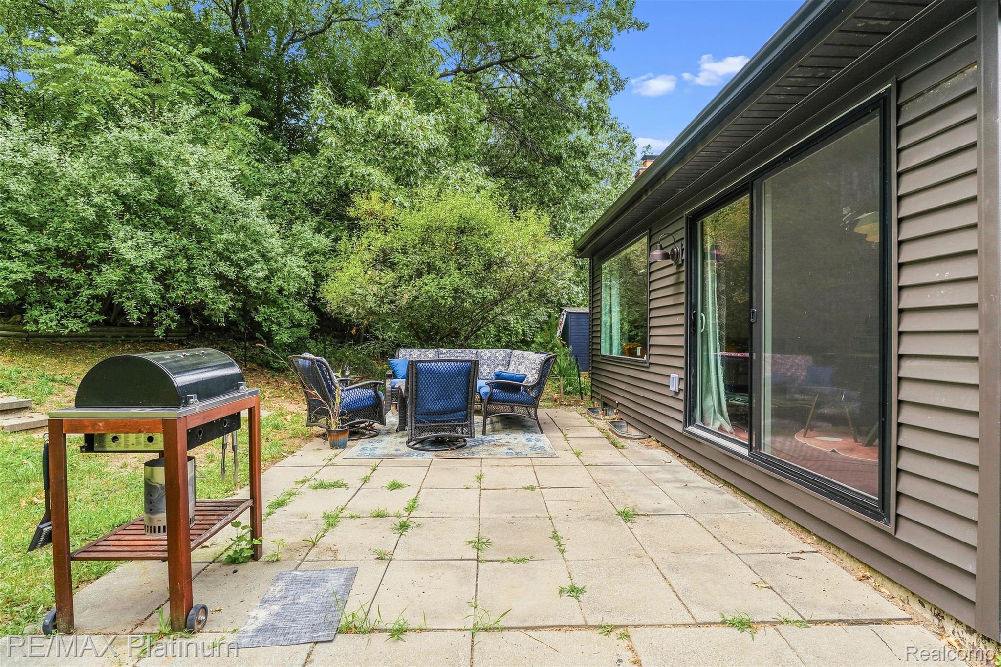 815 Oak Ridge Court Brighton, MI 48116 - Photo 36 of 37 Expansive patio featuring large format pavers, an exterior wall with horizontal siding, and large sliding glass doors