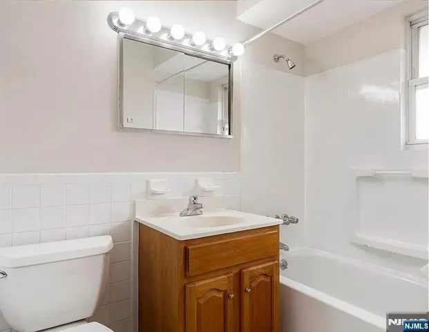 a bathroom with a sink mirror vanity and toilet