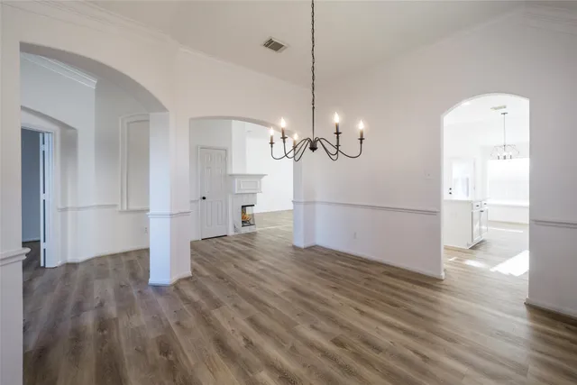 a view of a room with wooden floor staircase and a kitchen space